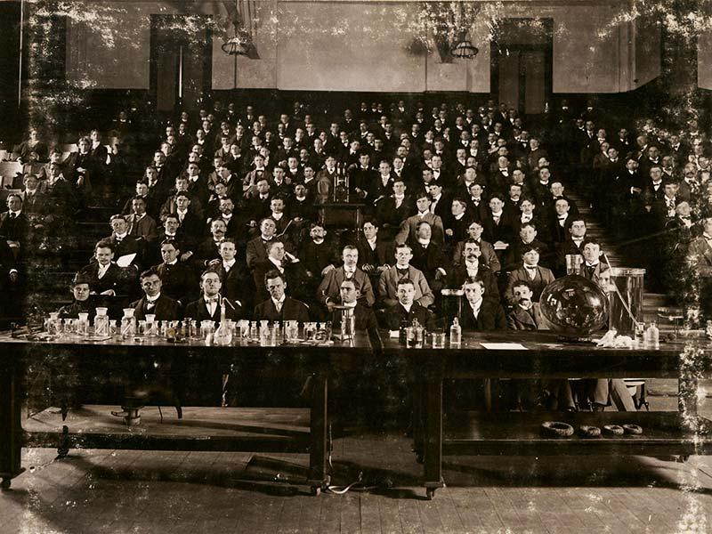 Well-dressed students pose for a photo in a chemistry class around the turn of the century. 