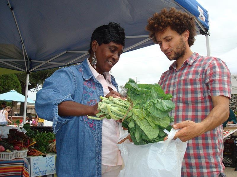 New Orleans resident Linda Hughes buys greens from Sankofa Farmers Market vendor Jamal Elhayek