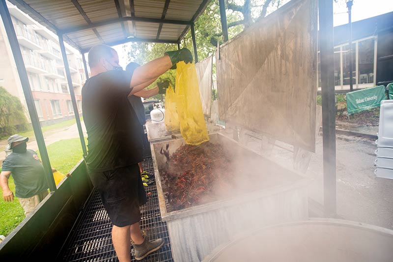 Johnny Randazzo, owner of Johnny’s Seafood, empties a sack of live crawfish into one of several boiling pots along Drill Road.