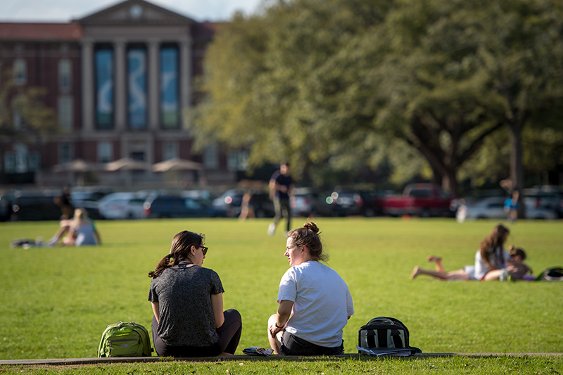 Friends gather to soak up the sun on the Berger Family Lawn.
