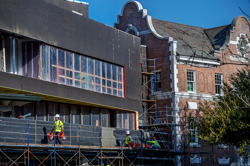Workers begin plastering the exterior of the 2nd floor terrace on the addition to Mussafer Hall on the uptown campus. The Mussafer Hall addition is a study in juxtaposition.