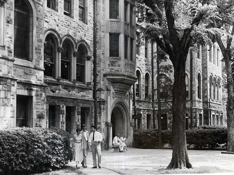 Students are caught walking and talking outside Dinwiddie Hall on the uptown campus circa 1950.