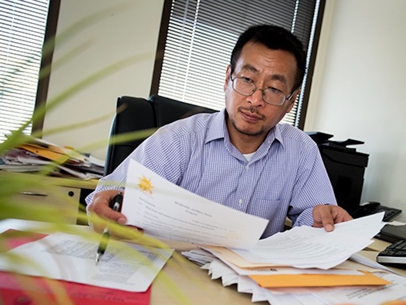 Dr. Lu Qi, HCA Regents Distinguished Chair and professor at the Tulane University School of Public Health and Tropical Medicine, sits at a table and reads research