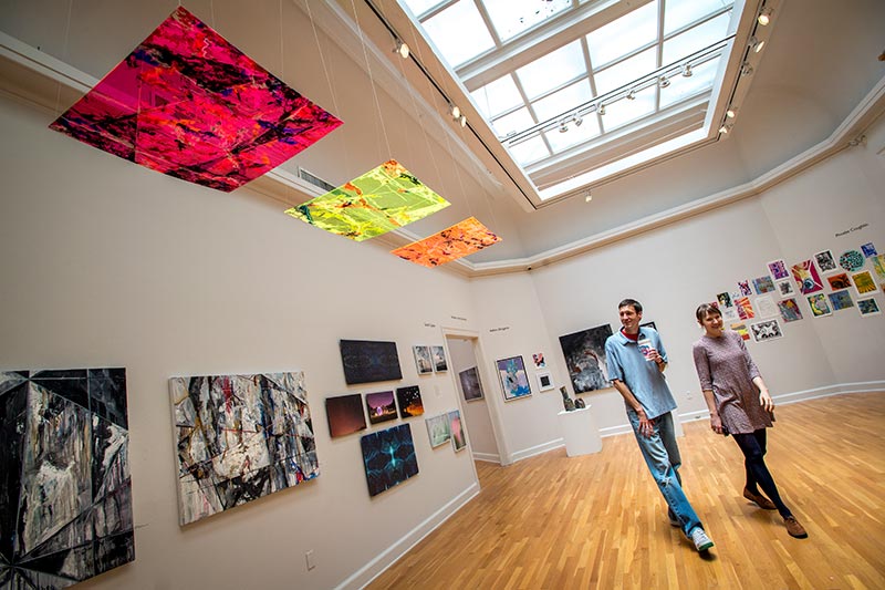 Professors take a stroll through an exhibition of student work in the Carroll Gallery.