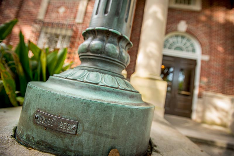 Decades of patina adorn the base of a light post outside of Dixon Hall on Tulane’s uptown campus.