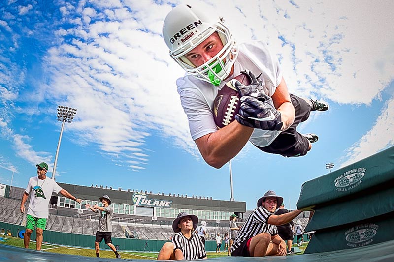 Reed Green, a sophomore wide receiver from Meridian, Mississippi, launches over bags during a drill on the first day of practice for the 2016 Green Wave football team held in Yulman Stadium on Friday (Aug. 5). 