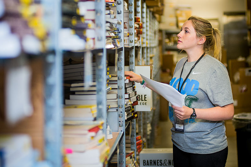 Incoming first-year student Emilie Redmann, works in the stockroom of the Tulane bookstore filling textbook orders for arriving students.