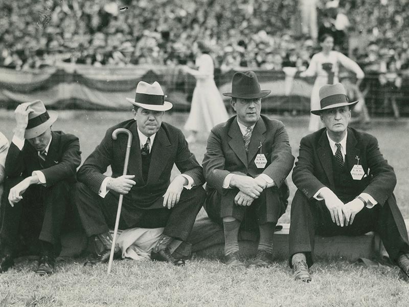 Huey P. Long, second from left, former governor of and senator for Louisiana sits on the sidelines of a Tulane-LSU football game.