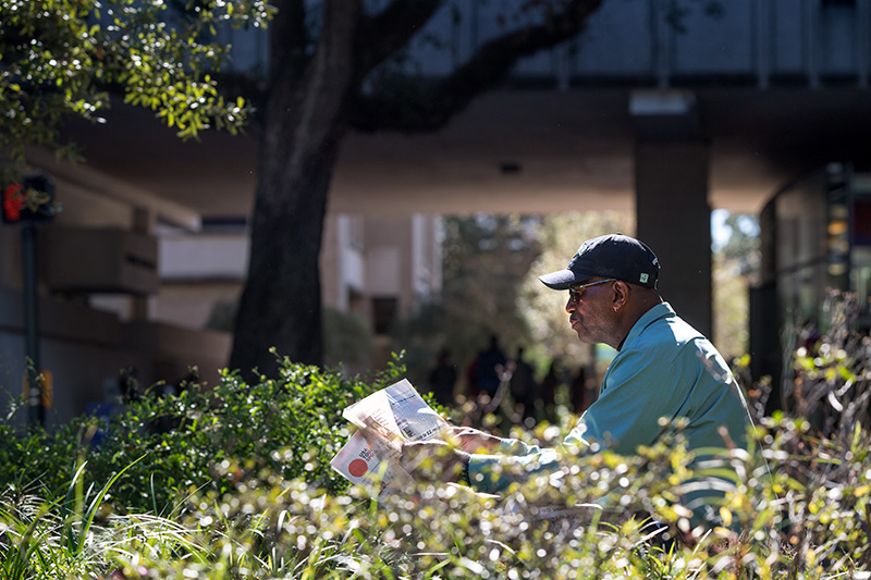 During his lunch break, Charlie Williams, a Tulane staff member with Facilities Services, reads the day’s news on his favorite bench near Freret Street and McAlister Place. Tulane staffer’s daily routine includes the busiest corner on campus.