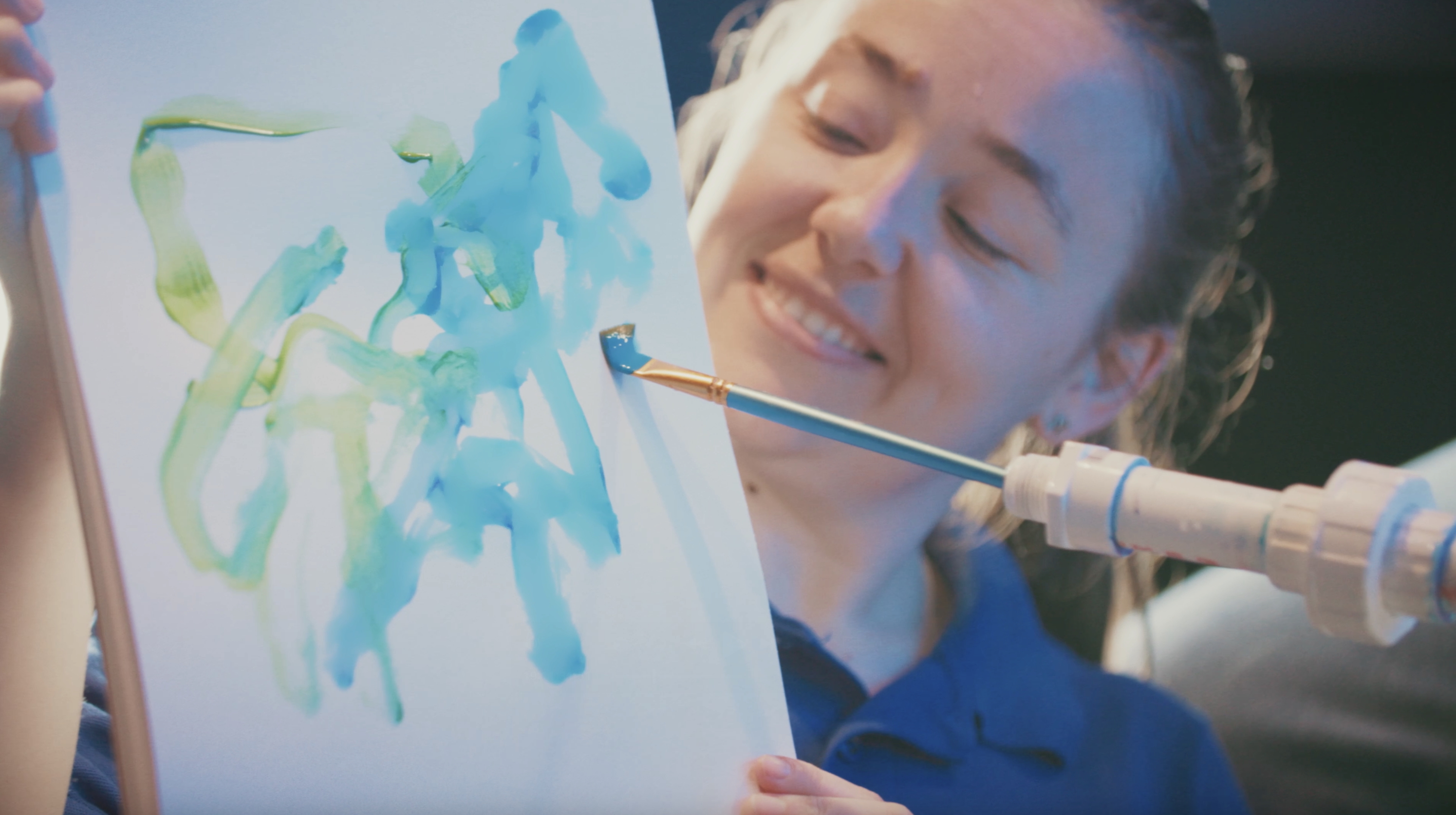 An aquarium worker holds up the canvas for the sting rays to paint on.