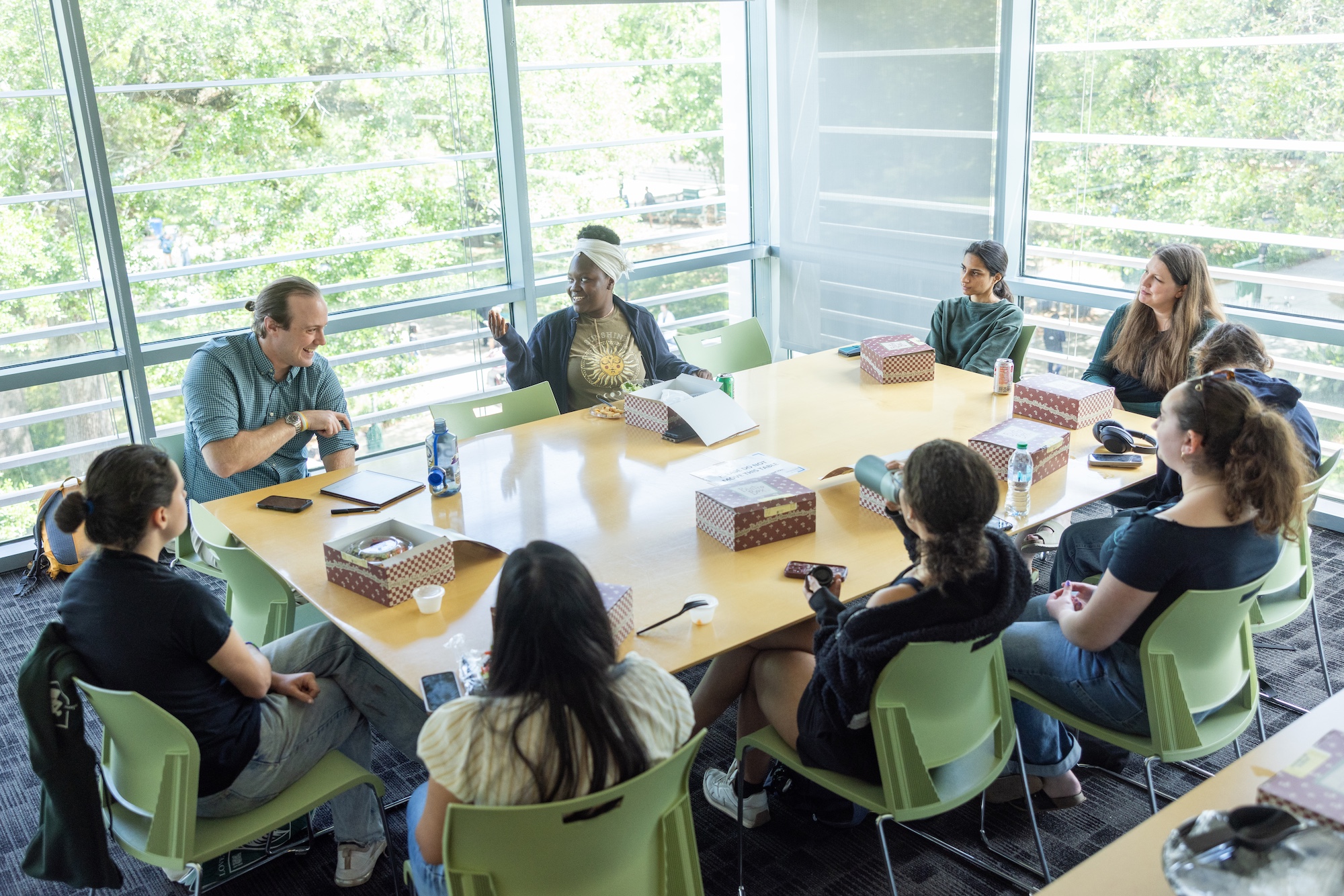 
Group of people having a discussion around a table in a bright room. 