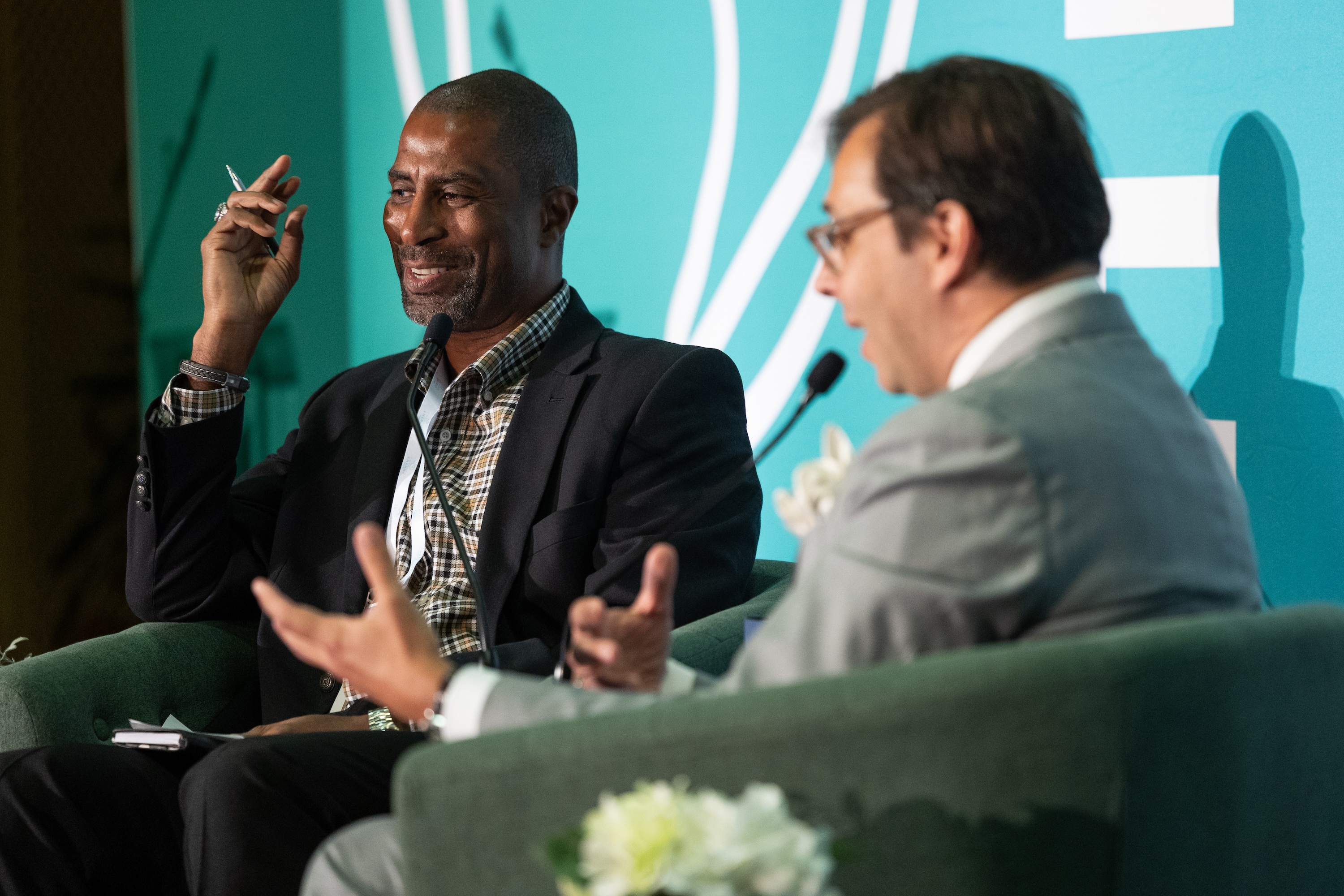 
Gary Hoover gestures while conversing with another man on stage. 