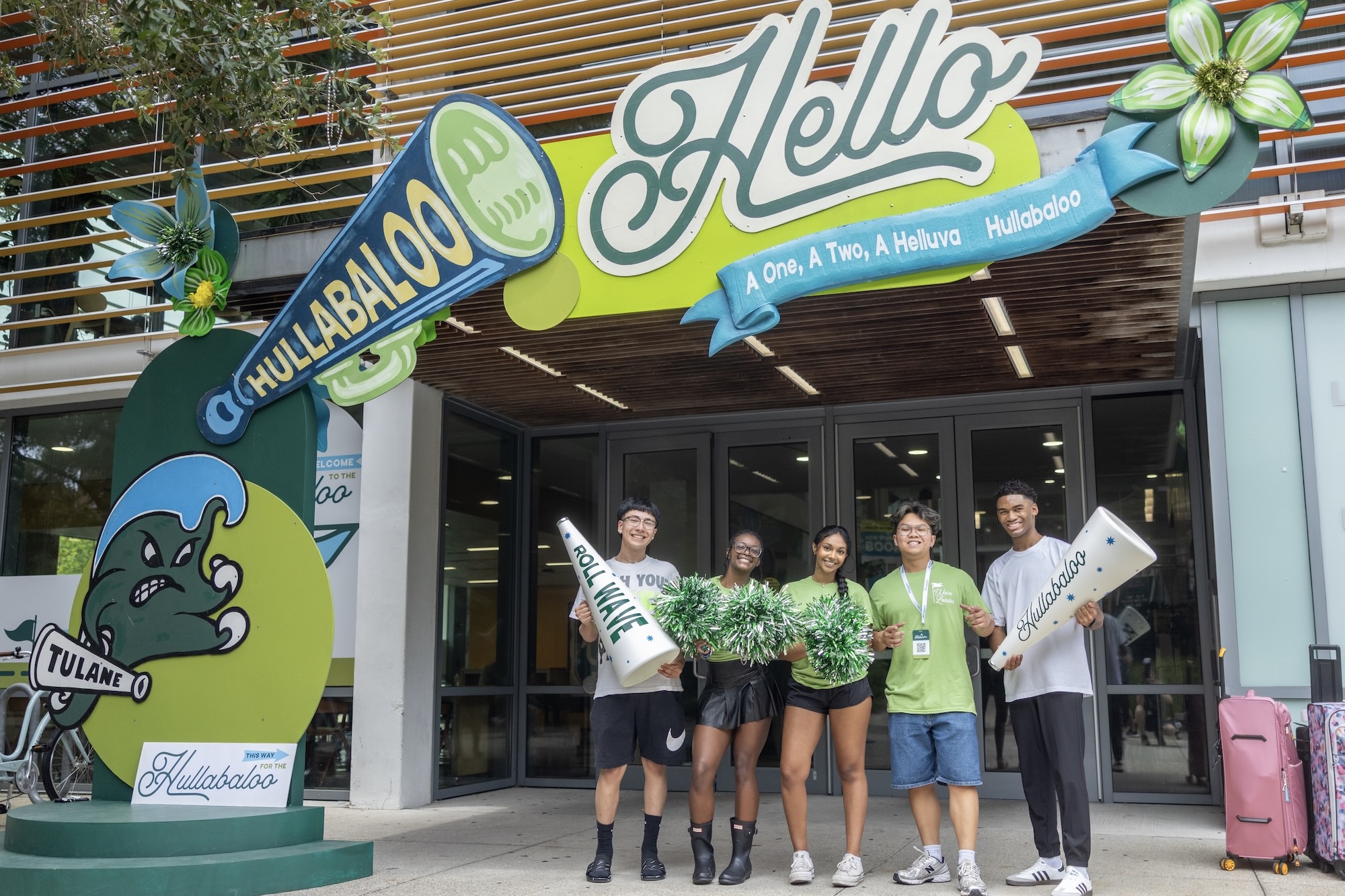 
Five students with spirit gear in front of a building decorated for a "Hello Hullabaloo" event. 