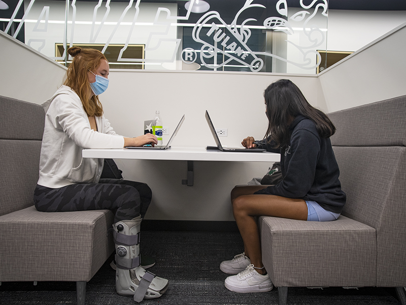Mackenzie Clark (left), and Lahari Yelamanchili (right), Green Wave tennis players, study in one of the booths in the center. 