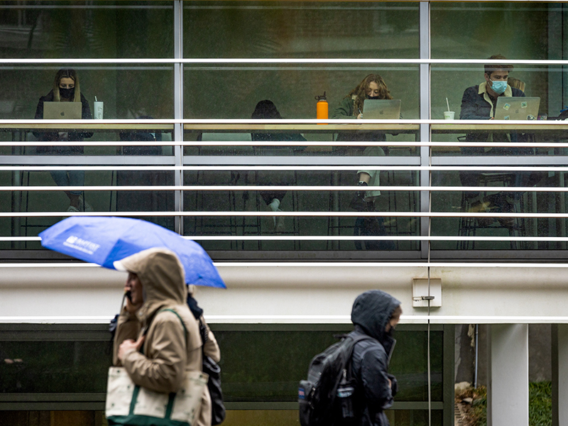 Students take shelter from the weather to work in the James Lounge of the Lavin-Bernick Center for University Life.