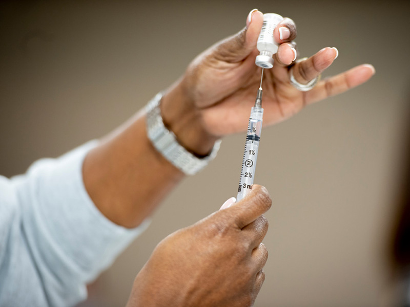 COVID-19 vaccine needle being prepared