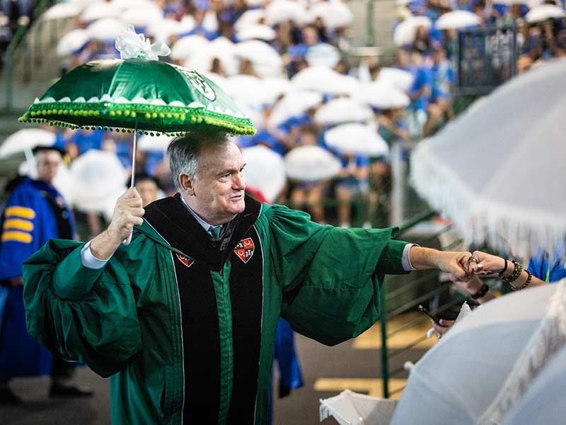 President Fitts fist bumps students while second-lining following the Convocation ceremony. 