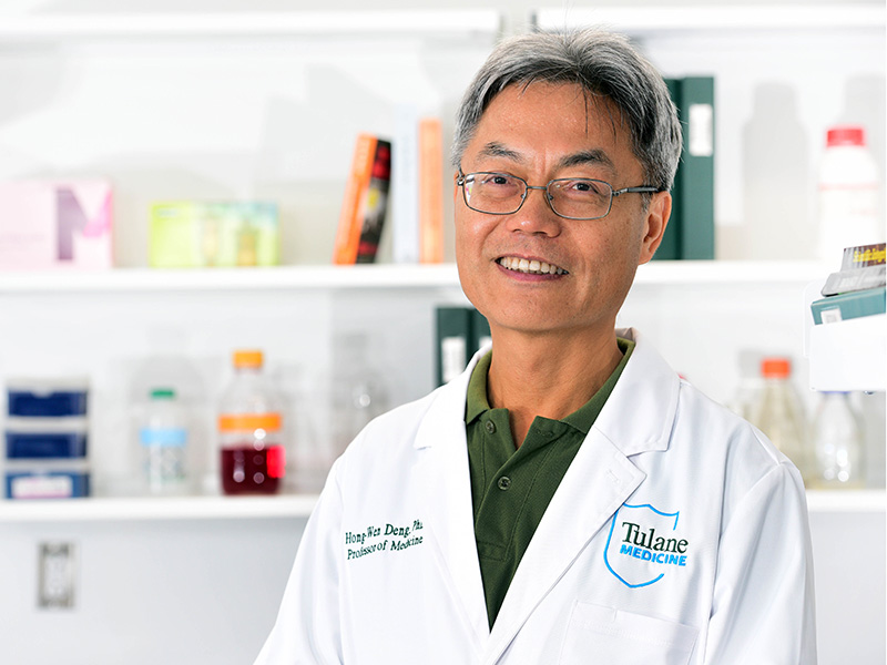 Dr. Hong-Wen Deng, who leads the Center for Biomedical Informatics and Genomics at Tulane University School of Medicine, stands in a lab coat.