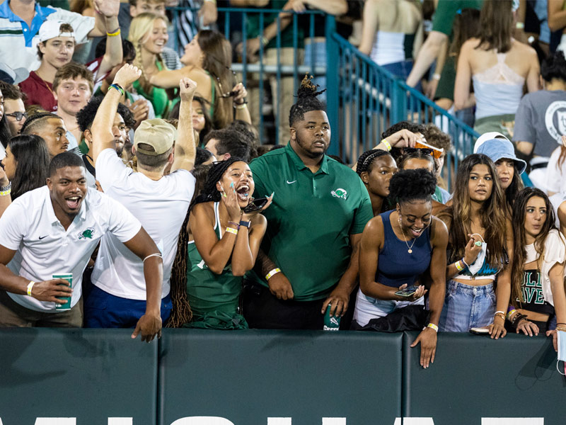 Fans cheer on the Green Wave in the stands. 