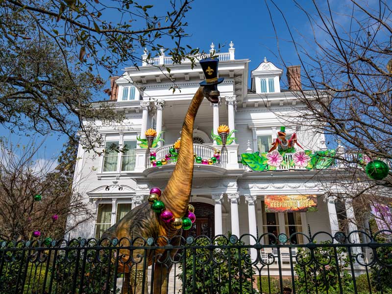 At the Dino Gras on the Avenue, costume-loving prehistoric creatures frolic on the front yard of the Fayards' home