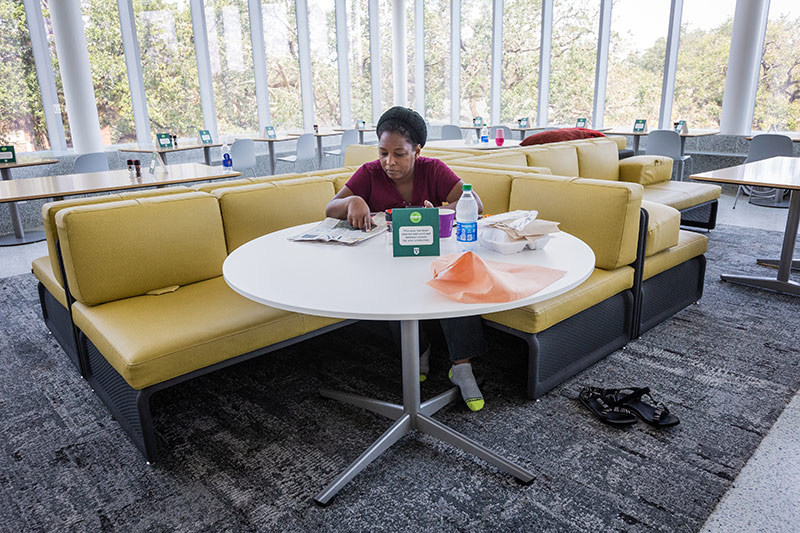 Makisha Graham, a coordinator for dining with Sodexo, reads a newspaper on her day off. Graham has been sleeping in this portion of The Commons. 