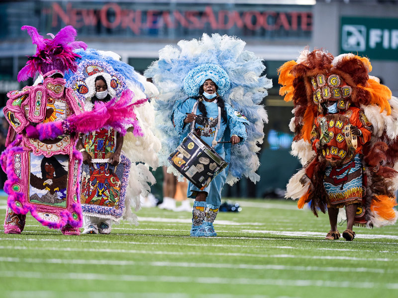 Mardi Gras Indians parade across the football field before the start of the game. 