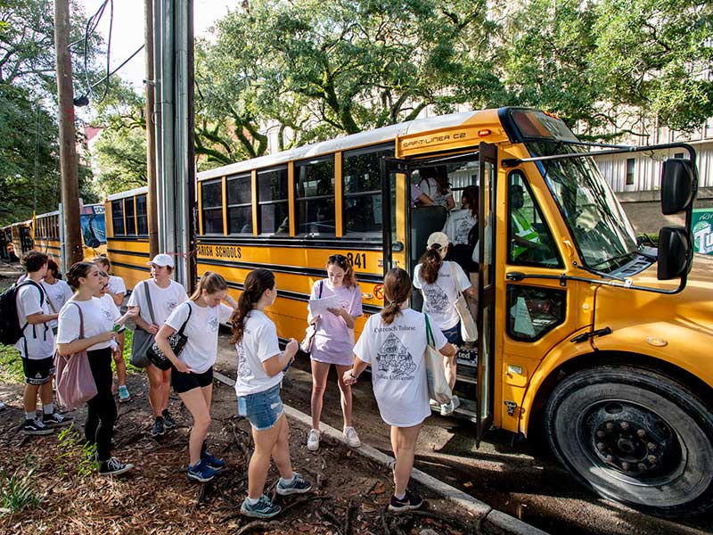 Students board buses along Freret Street.