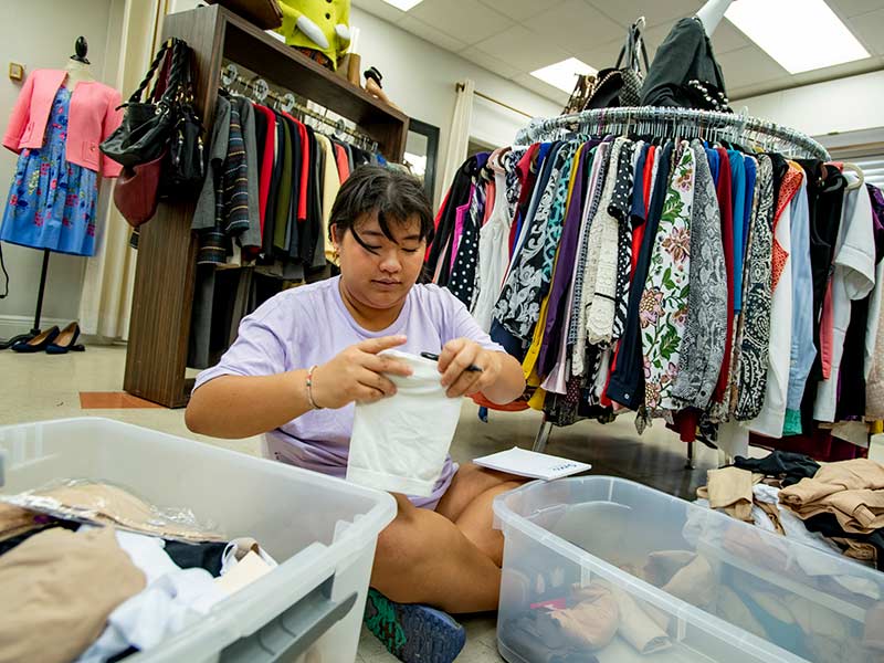 Tulane junior and member of the Outreach executive board Katie McCormick organizes clothes in the boutique at the New Orleans’ chapter of Dress for Success.