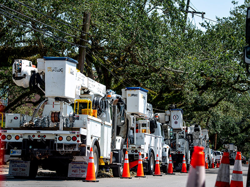 Entergy and contractor power trucks line Freret Street staged for repairs to power lines.