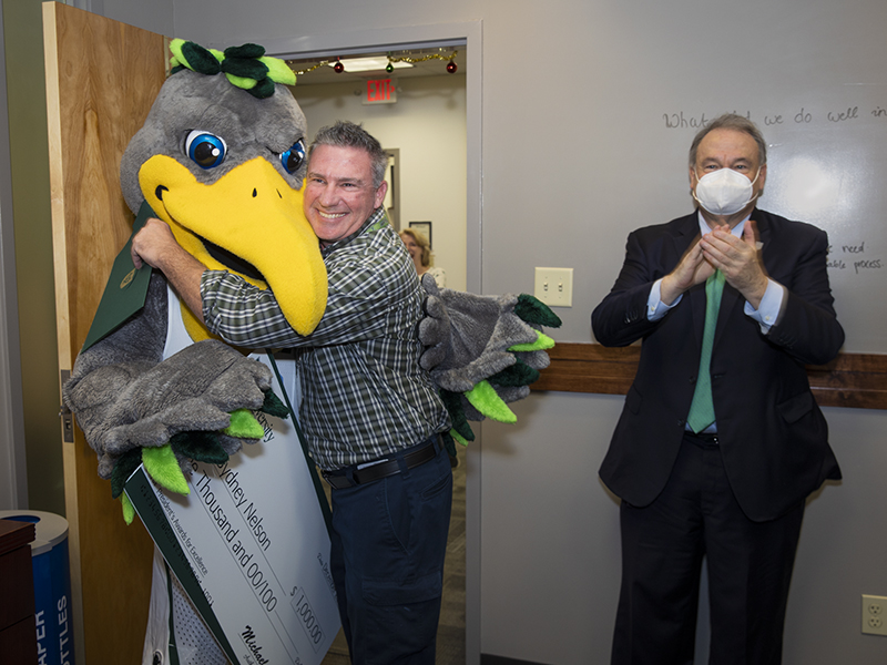 Sydney Nelson, zone manager of downtown Facilities Services, gives Riptide a hearty hug upon receiving his award.