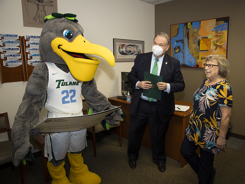 Cindy Stewart, senior executive secretary of the Department of Biomedical Engineering at the School of Science and Engineering, laughs with President Fitts and Riptide upon her award presentation.