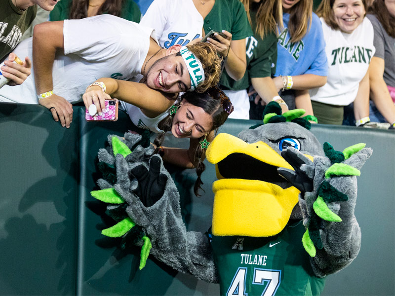 Tulane's mascot Riptide poses for a selfie with fans.