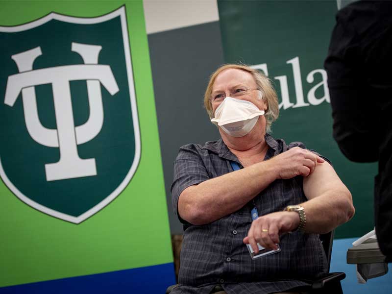 Robert Garry, research virologist in the Tulane School of Medicine, rolls up his sleeve to get the vaccination.
