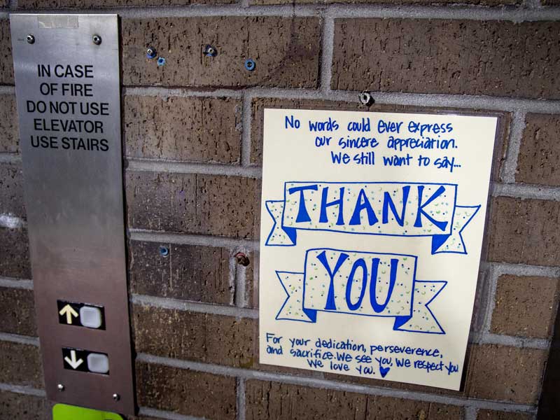 A handwritten sign made by TMC’s Child Life/Arts in Medicine thanking frontline workers is posted next to the elevator in LaSalle parking garage 