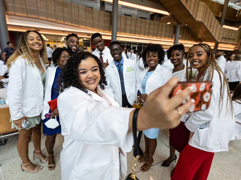 Excited students gather to take a group selfie following the ceremony. 
