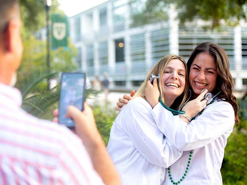 Elizabeth Romantz (left) and Sara Yuter pose for a photo after receiving their white coats and stethoscopes.