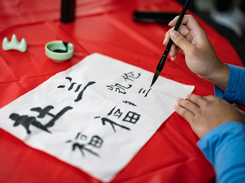 Martin uses a small brush to write Chinese characters during the Lunar New Year celebration.