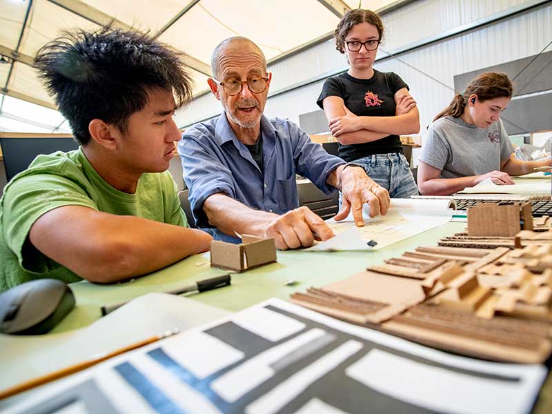During a first-year architecture studio class, Professor Kenneth Schwartz guides Ming Hoang Huan, left, and Sofia Lovera, right, on how to approach the existing site of a project location.