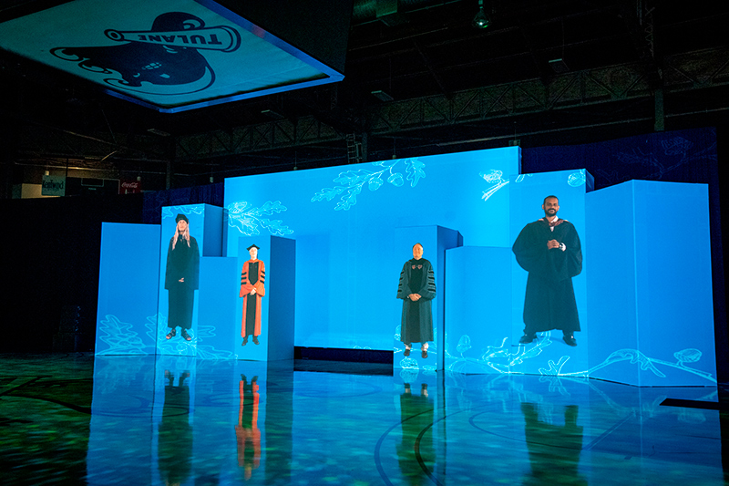 Larger-than-life video versions of Newcomb-Tulane College Dean Lee Skinner, Provost Robin Forman, Tulane President Michael Fitts
