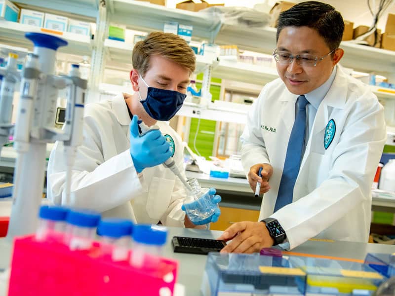 Tony Hu and researcher in lab