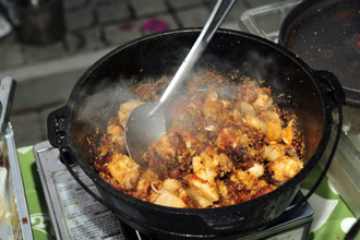 A savory dish being prepared at food festival.