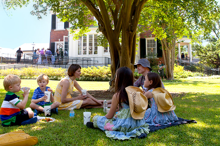 Family on the lawn of the Bea Field Alumni House