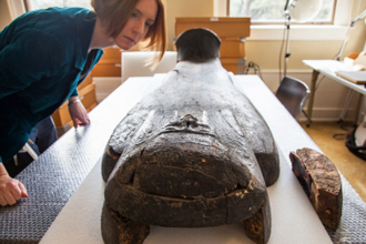 Melinda Nelson-Hurst looks over one of the Egyptian artifacts at Tulane.