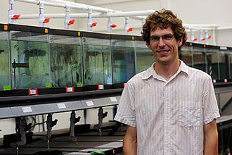Travis Haas, a doctoral student in ecology and evolutionary biology is lead author of a study about a species of river fish that morphs into a new shape in response to a lake-like environment. (Photo by Sally Asher)
