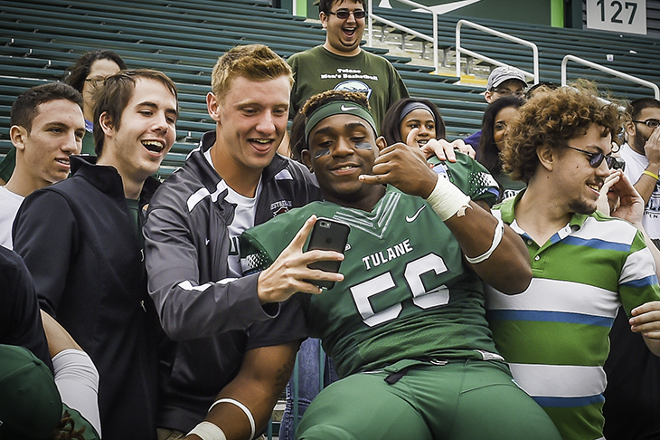 Students and players celebrate the Green Wave football team