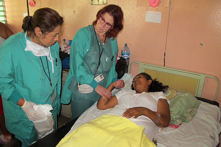 On a trip hosted by New Orleans Medical Mission Services to Leon, Nicaragua, Dr. Margie Kahn, center, checks on a woman who received pelvic surgery.