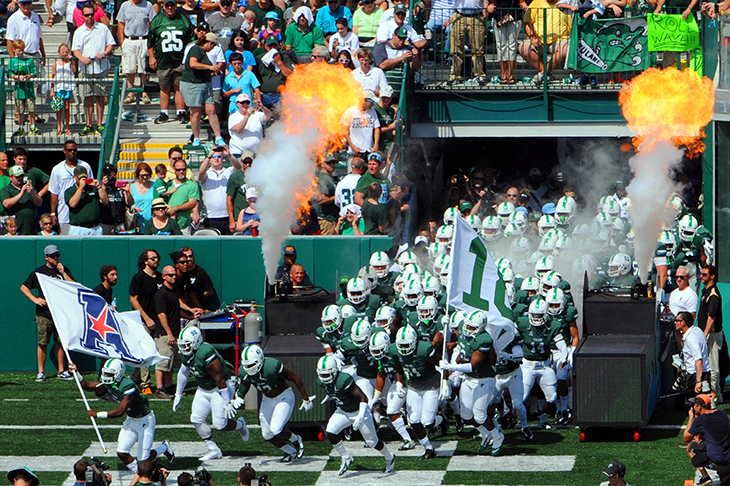 Football players enter the field with pryotechnics