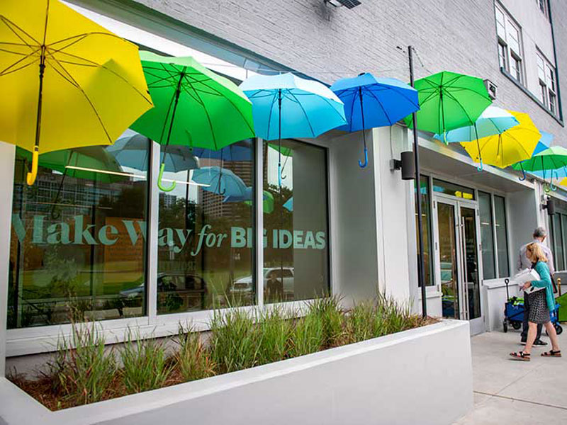 Innovation Institute grand opening with decorative green, blue and yellow umbrellas on the front of the building