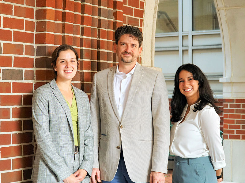 Haley Gentry (left) and Ximena De Obaldia (right) are this year’s fellows, and Christopher Dalbom (center), institute director, is a former fellow.