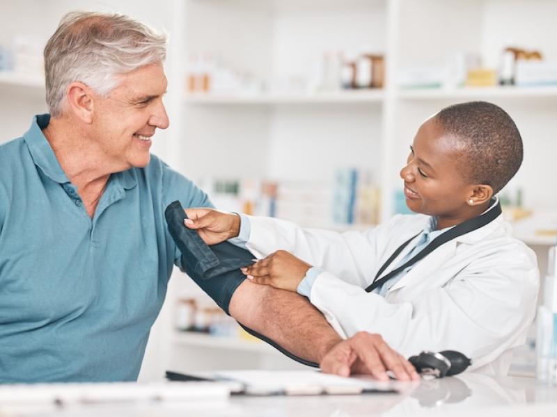 A pharmacist takes a man's blood pressure